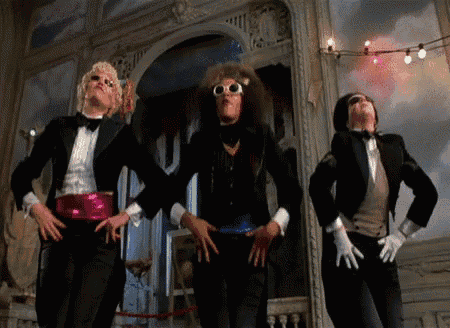 three men in tuxedos and gloves are dancing in a room