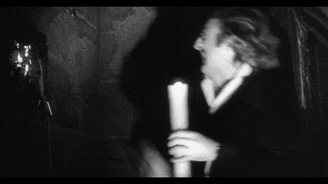 a black and white photo of a man holding a candle with the words ma è un malocchio questo