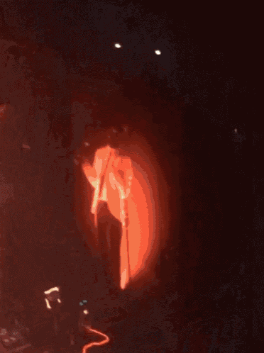 a man singing into a microphone on stage in a dark room