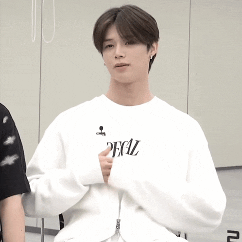 a young man wearing a white sweater with the word deal on it