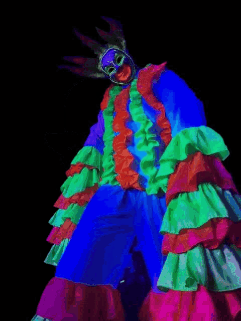 a clown on stilts is glowing in the dark and has a crown on his head