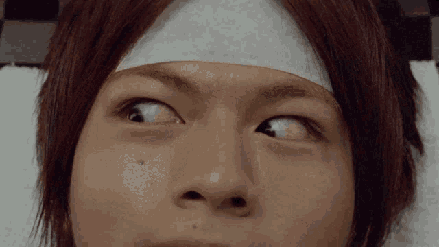 a close up of a man 's face with a bandage on his forehead