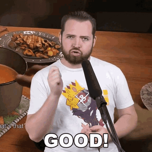 a man with a beard is giving a thumbs up in front of a microphone with the word good written on it
