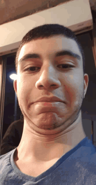 a man with a very long neck is making a sad face