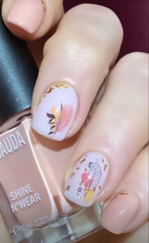 a close up of a woman 's nails and a bottle of shine n' wear nail polish