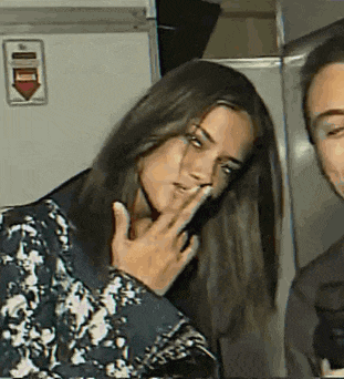 a woman covering her mouth with her hand in front of a man