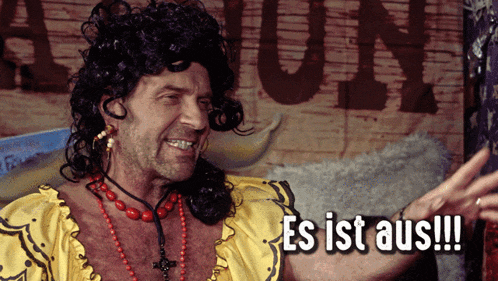 a man wearing a wig and a necklace says es ist aus !!!