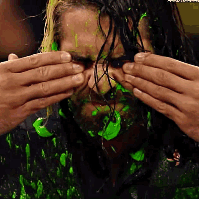 a wrestler with green slime on his face has the hashtag #thenextbig thing at the bottom