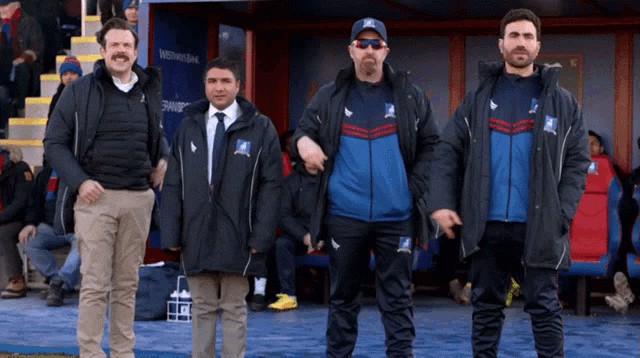 a group of men standing next to each other with one wearing a jacket that says ' td ' on it