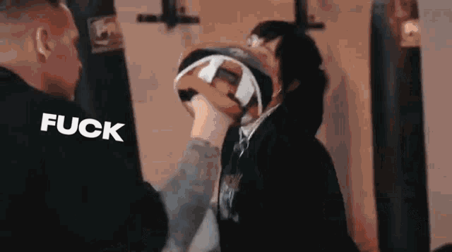 a man is hitting another man with a boxing glove in a boxing gym .