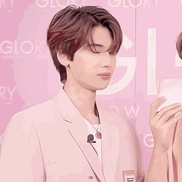 a young man in a pink suit is giving the middle finger