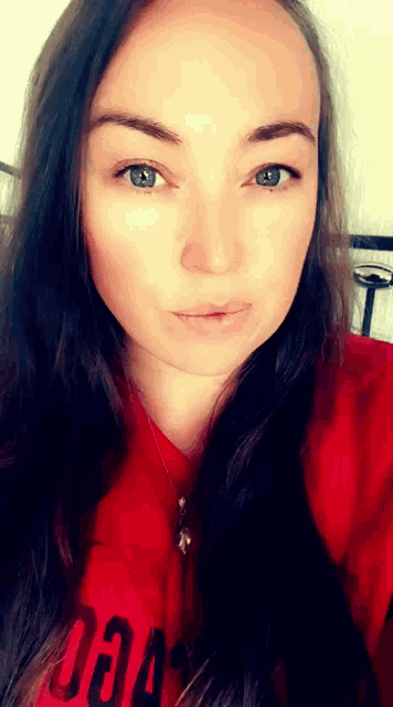 a woman wearing a red shirt that says ' oa ' on it