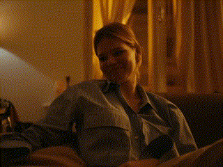 a woman in a suit is sitting on a couch with the words `` whatever suits you babe '' above her .