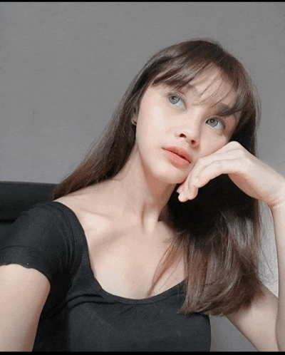 a woman with a hand on her chin looks to the side