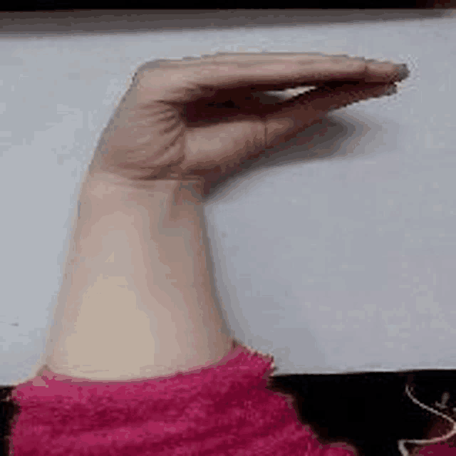 a close up of a person 's arm with a pink sweater on it .