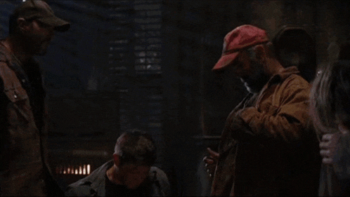 a man in a red hat is holding a flashlight and talking to a boy