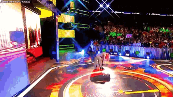 a man is kneeling down on a stage in front of a crowd and a sign that says the next big thing
