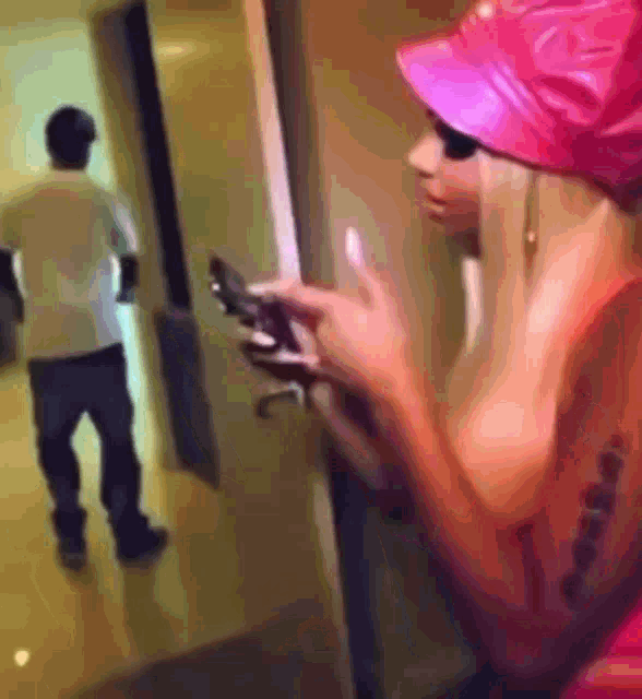 a woman wearing a pink hat is looking at her cell phone