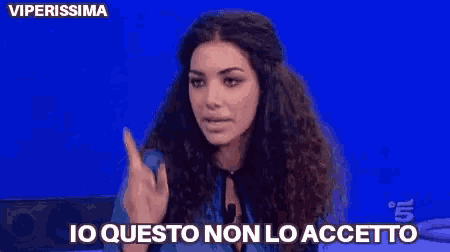 a woman with curly hair says io questo non lo accetto on a blue background