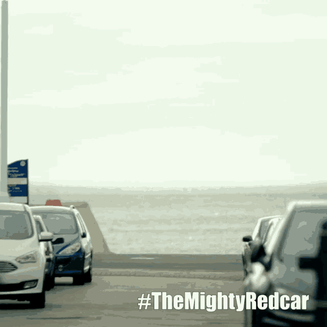 a row of cars are parked on the side of the road with #themightyredcar