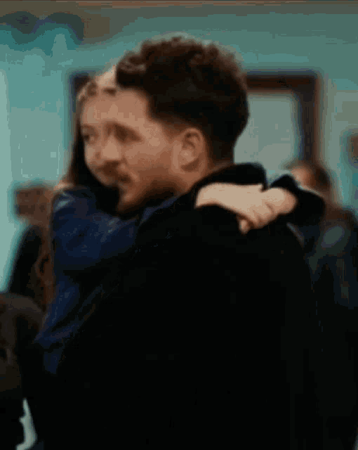a man is holding a little girl in his arms in a blurry photo .