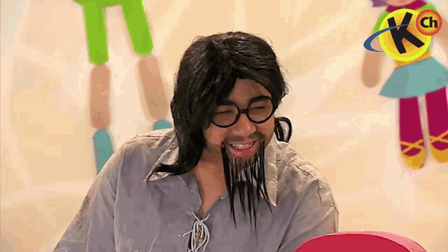 a man with a beard and glasses is smiling in front of a kch logo