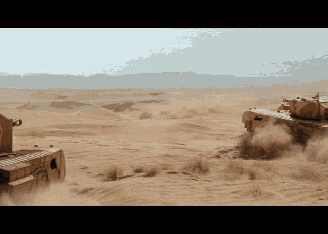 two military tanks are driving through a desert landscape