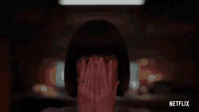 a woman is covering her face with her hands in a netflix trailer .