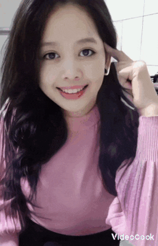 a woman in a pink sweater is making a funny face