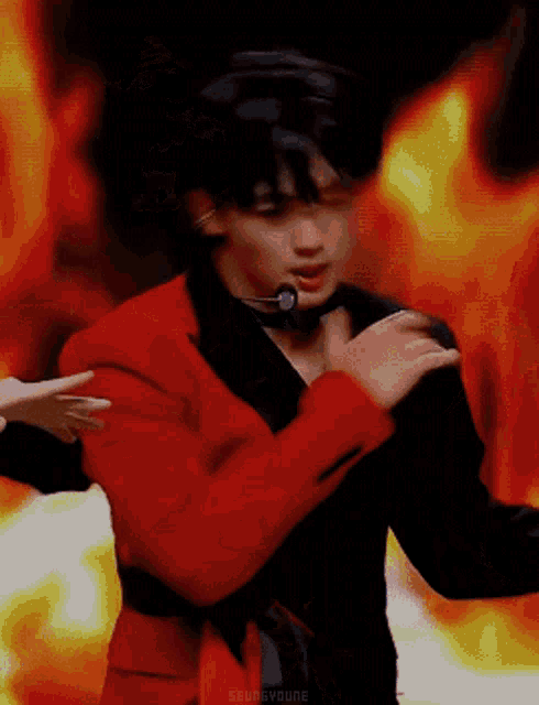 a man in a red jacket and black suit is dancing on a stage .