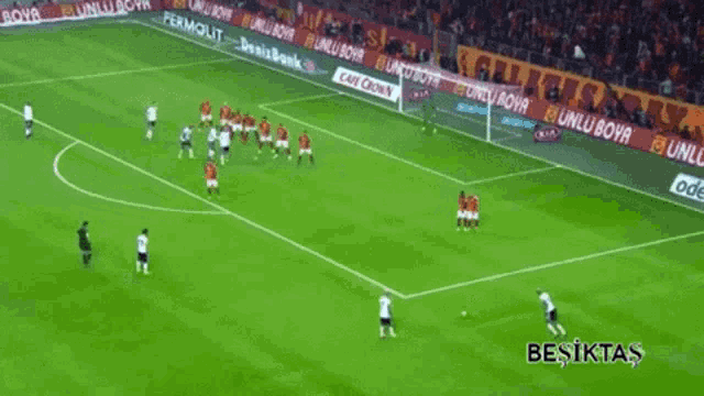 a soccer game is being played in a stadium with advertisements for permolit and cafe crowns