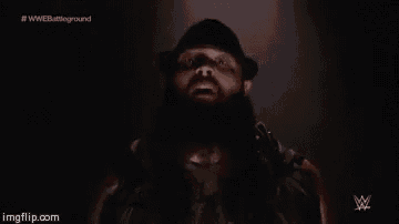 a man with a beard is wearing a hat and looking up at the camera .