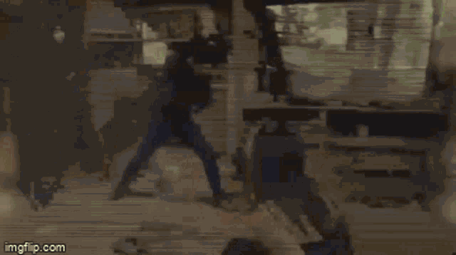 a man and a woman are fighting in a room with a sword .
