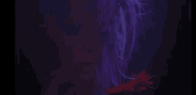 a woman with purple hair is holding a red flower in her hands .