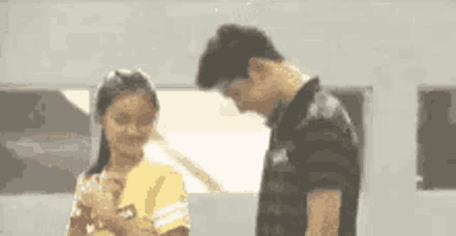 a man and a woman are standing next to each other .