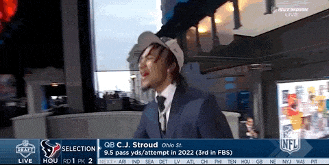 a man in a suit and tie is standing in front of a screen that says qb c.j. stroud ohio st.