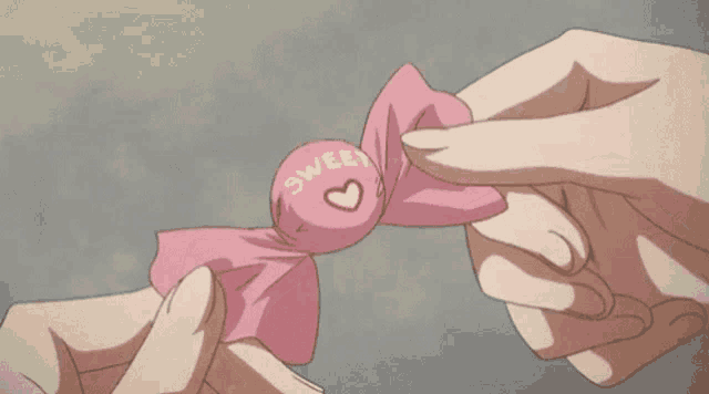 a person is holding a pink piece of paper that says ' n ' on it