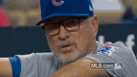 a man wearing a cubs hat and a mlb.com logo on his shirt