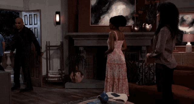 a woman in a pink dress is standing in a living room