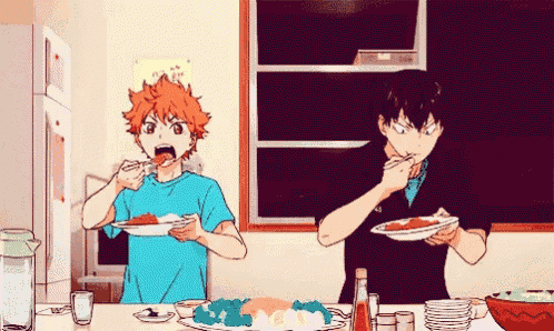 two anime characters are eating food at a table in a kitchen .
