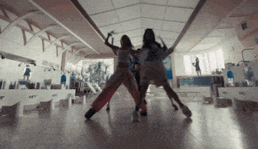 a group of women are dancing in a hallway with a sign that says ' a & t ' on it