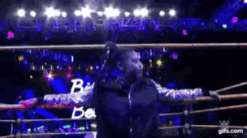 a man in a wrestling ring with the letters b and a on his chest