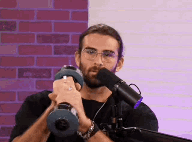 a man is holding a dumbbell in front of a microphone