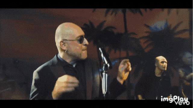 a man singing into a microphone with a watermark that says imgplay vevo