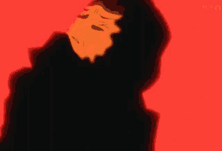 a man in a black hoodie is standing in front of a red background and covering his face with his hand .