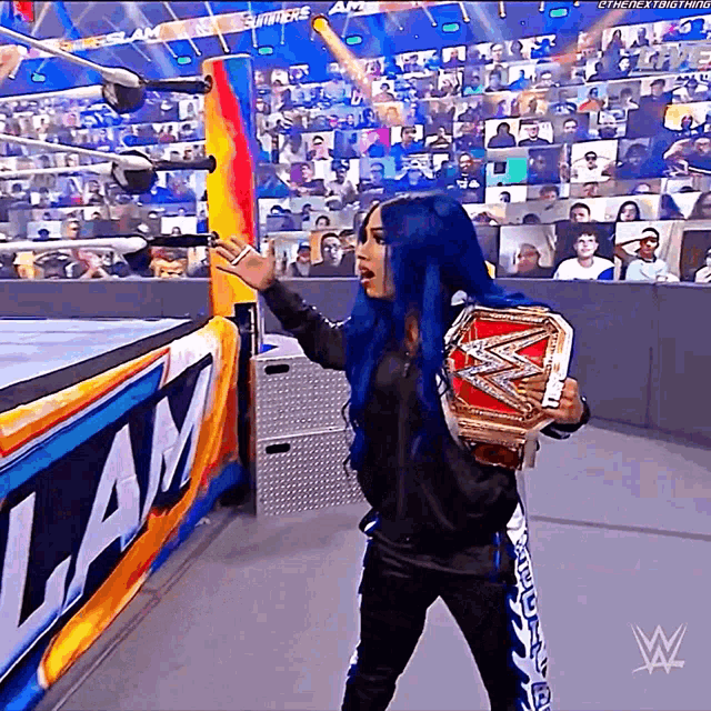 a woman in a wrestling ring holding a championship belt with the letter w on it
