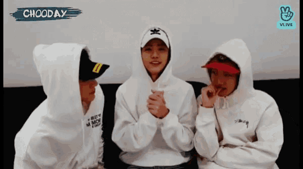 three men wearing white hoodies and hats are sitting on a couch with the word chooday written above them