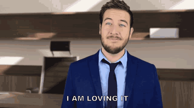 a man in a suit and tie says that he is loving it
