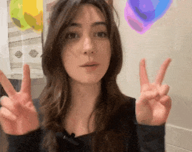 a woman giving a peace sign with her hands