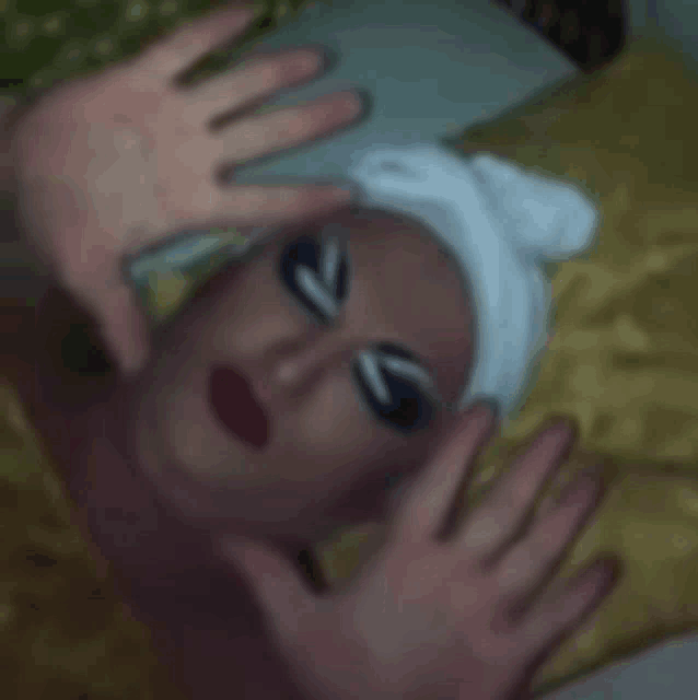 a woman with a towel on her head is laying on a bed with her hands outstretched .